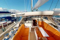 Luxurious 2012 Amel 64 yacht with orange seating and sleek design in a marina setting.