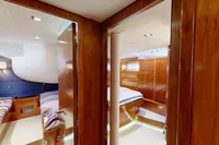 Luxurious interior of 2012 Amel 64 yacht with wood paneling and cozy cabins.