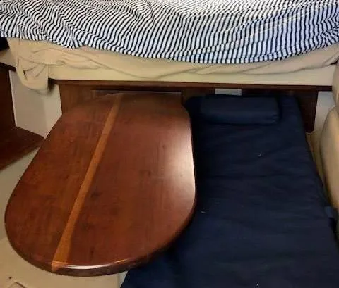 Rampage Yacht Photos Pics Interior of 2001 Rampage 30 Express boat with wooden table and striped bedding.