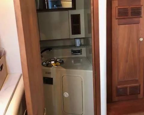 Rampage Yacht Photos Pics Compact bathroom inside a 2001 Rampage 30 Express boat, featuring a sink and wooden cabinetry.