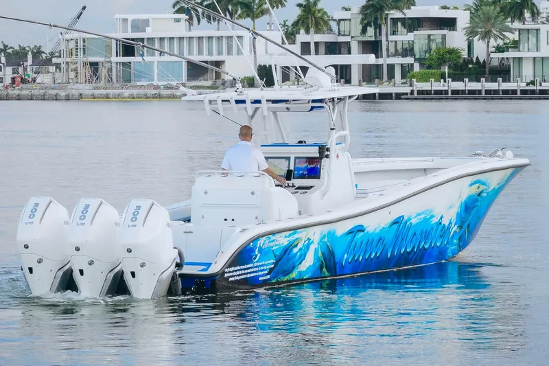  Yacht Photos Pics 2007 Yellowfin 36 Offshore boat with vibrant graphics and triple outboard motors on calm water.