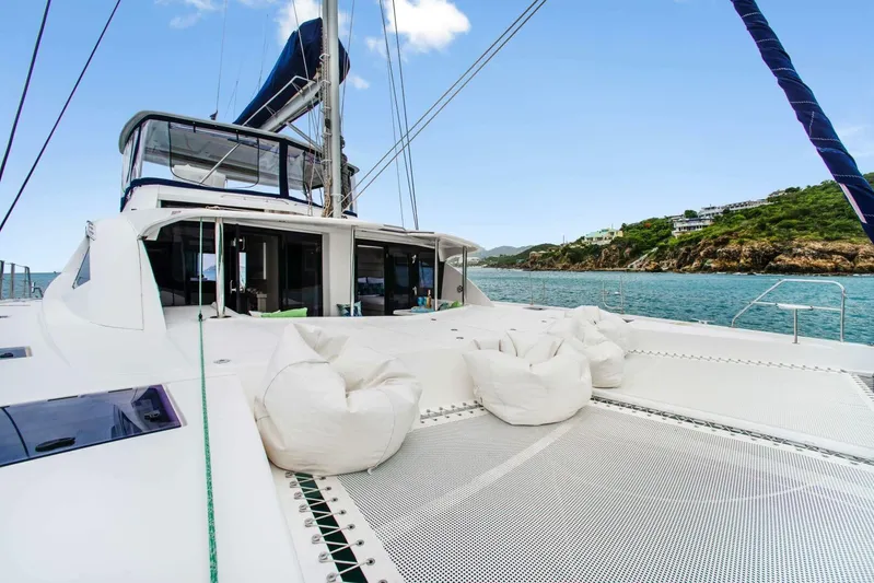 Deep Blue Yacht Photos Pics 2016 Leopard 58 Catamaran with bean bags on deck, sailing near a scenic coastline.