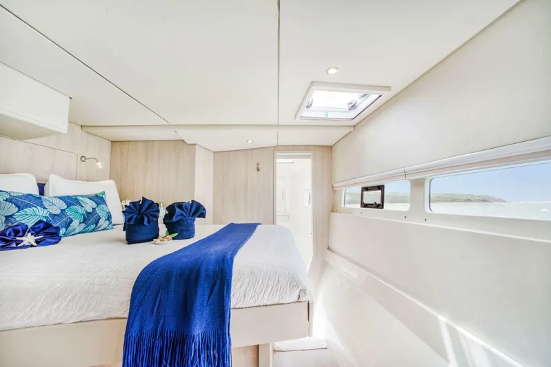 Deep Blue Yacht Photos Pics Luxurious interior of 2016 Leopard 58 Catamaran with elegant bedding and ocean view.