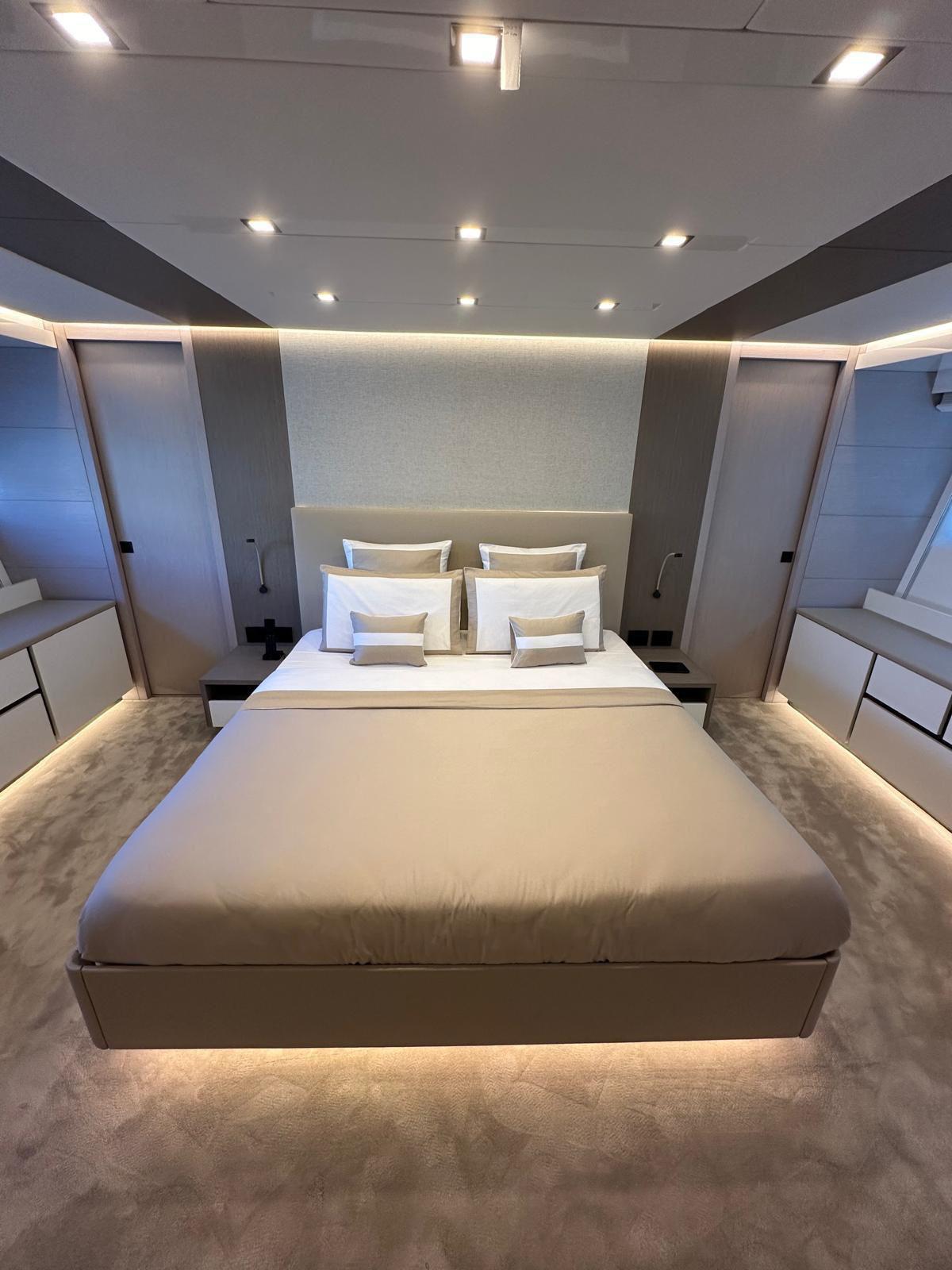 Luxurious modern bedroom with ambient lighting, featuring a plush bed and sleek design elements.