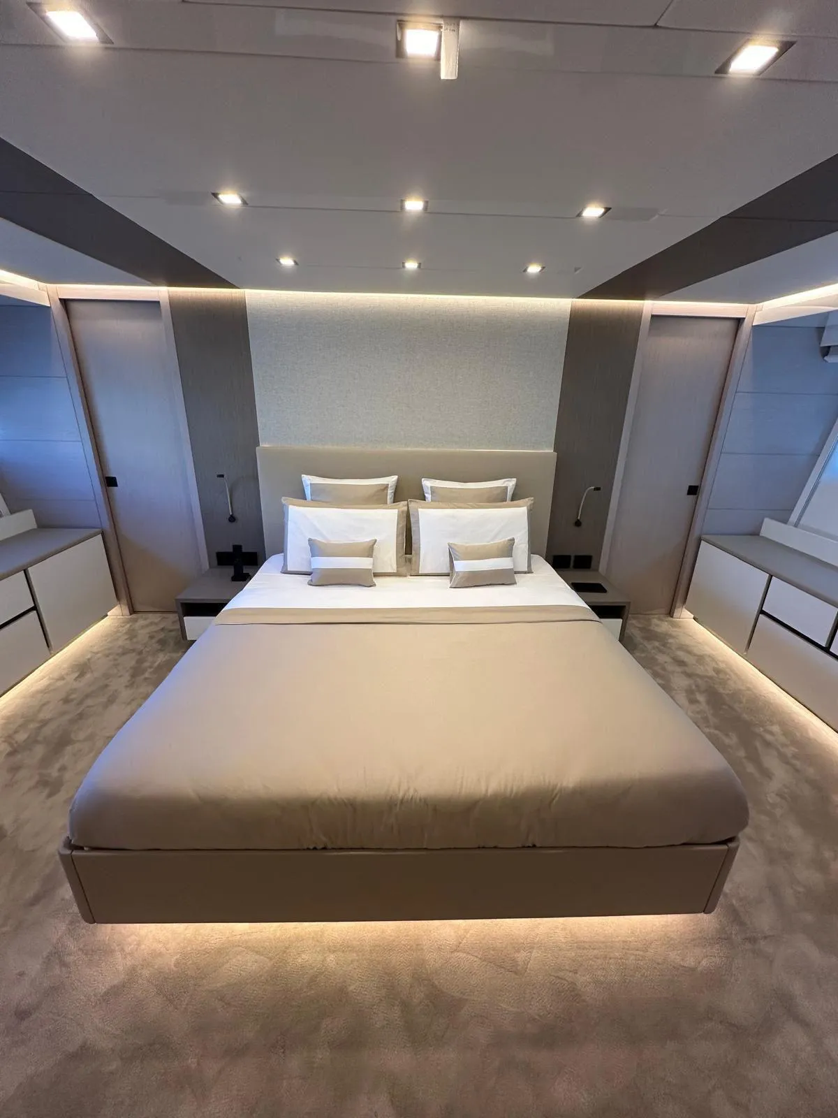 Luxurious modern bedroom with ambient lighting, featuring a plush bed and sleek design elements.