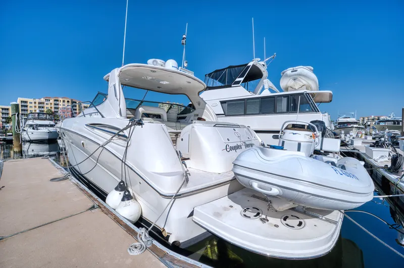 Couples Therapy Yacht Photos Pics 2001 Sea Ray 510 Sundancer yacht docked with inflatable boat, clear blue sky.