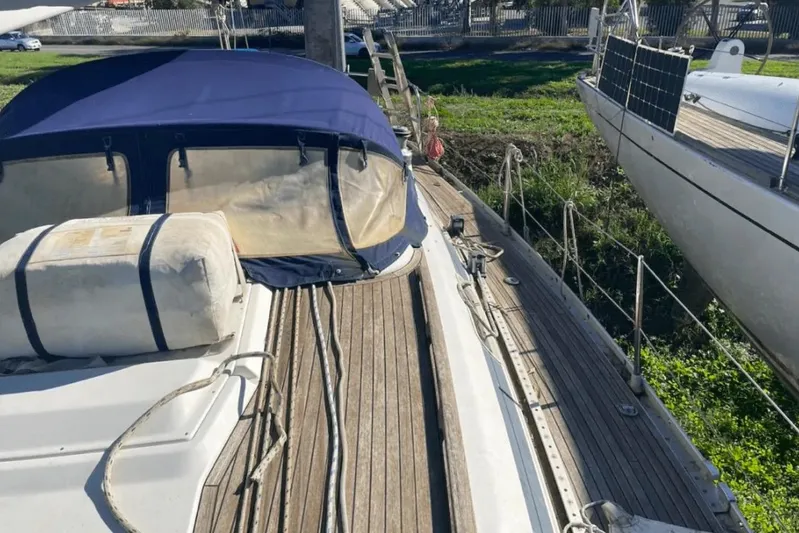  Yacht Photos Pics 2003 Cantiere del Pardo Grand Soleil 43 sailboat with wooden deck and blue canopy.