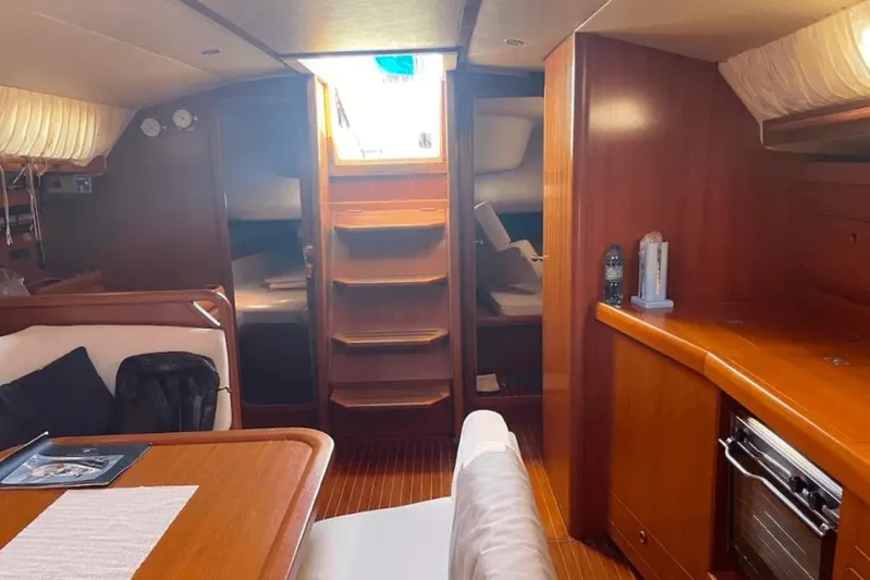  Yacht Photos Pics Interior of 2003 Cantiere del Pardo Grand Soleil 43 yacht, featuring wood finishes and cozy seating.