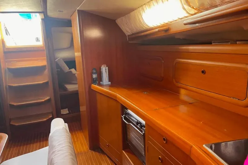  Yacht Photos Pics Interior of 2003 Cantiere del Pardo Grand Soleil 43 yacht with wooden cabinetry and seating.