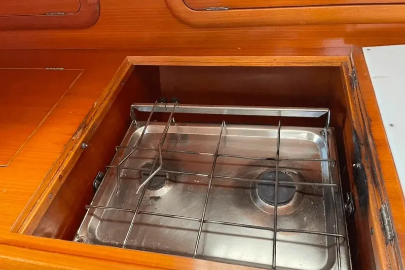  Yacht Photos Pics Stove in 2003 Cantiere del Pardo Grand Soleil 43 yacht kitchen, featuring wooden cabinetry.