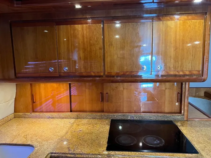  Yacht Photos Pics 2004 Bertram 670 yacht kitchen with wooden cabinets and granite countertops