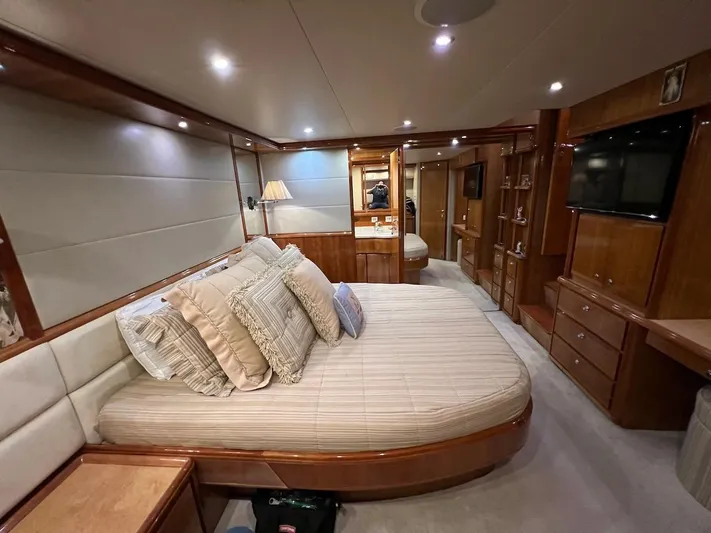  Yacht Photos Pics Luxurious bedroom interior of a 2004 Bertram 670 yacht with plush bedding and wooden furnishings.