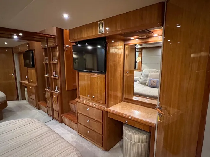  Yacht Photos Pics Luxurious wooden interior of a 2004 Bertram 670 yacht bedroom with TV and vanity.
