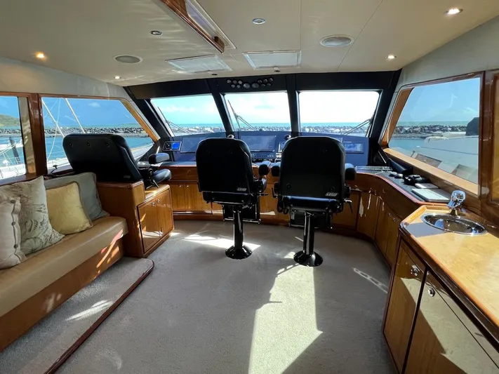  Yacht Photos Pics Interior helm of 2004 Bertram 670 yacht with panoramic windows and dual captain chairs.