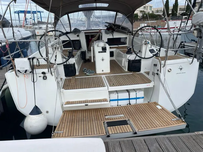  Yacht Photos Pics 2020 Jeanneau Sun Odyssey 440 sailboat with dual steering wheels and teak deck in marina.