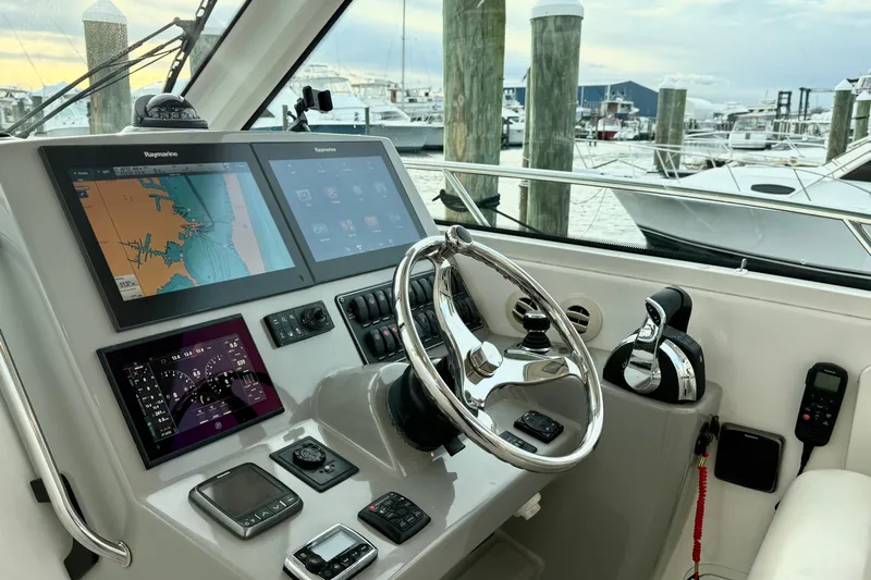  Yacht Photos Pics Control panel of 2014 Boston Whaler 345 Conquest Pilothouse with navigation screens and steering wheel.