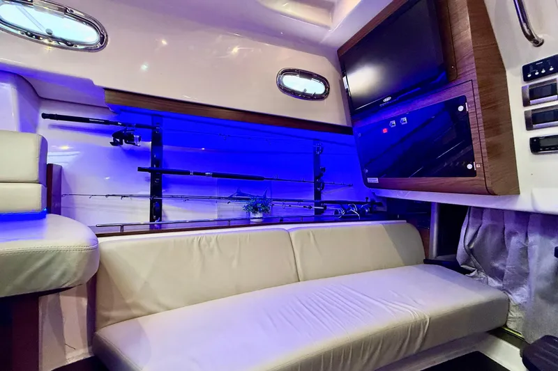  Yacht Photos Pics 2014 Boston Whaler 345 Conquest Pilothouse interior with seating, fishing rods, and blue lighting.