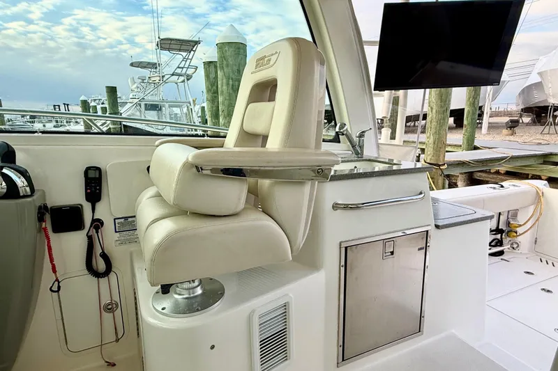  Yacht Photos Pics 2014 Boston Whaler 345 Conquest Pilothouse interior with captain's chair and control panel.