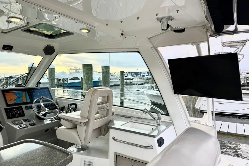  Yacht Photos Pics Interior of 2014 Boston Whaler 345 Conquest Pilothouse with helm and marina view.
