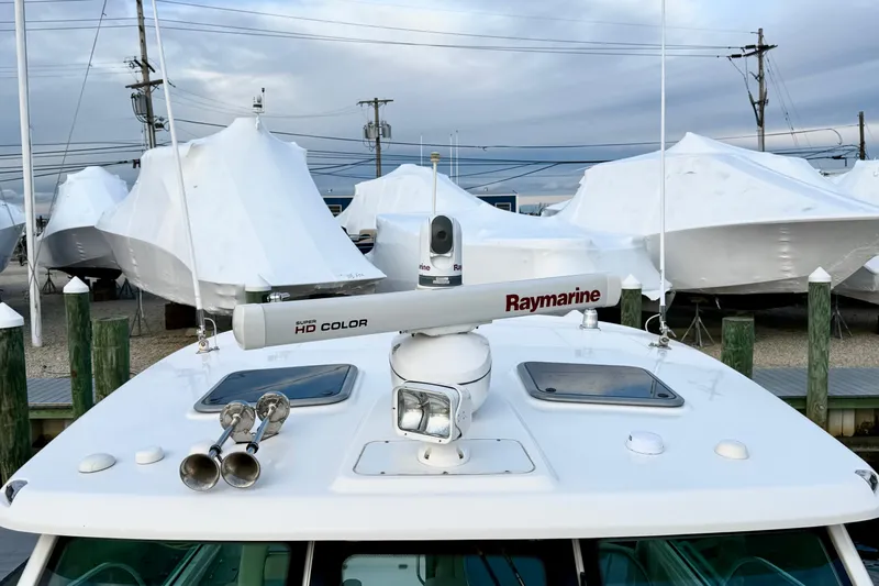  Yacht Photos Pics 2014 Boston Whaler 345 Conquest Pilothouse with Raymarine radar, docked among covered boats.