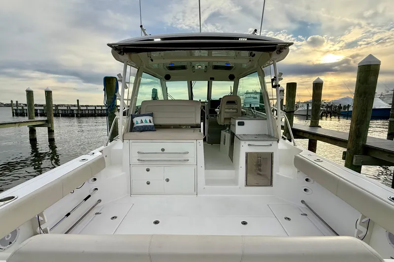  Yacht Photos Pics 2014 Boston Whaler 345 Conquest Pilothouse docked at sunset, showcasing spacious deck and seating.