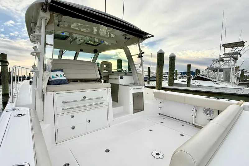  Yacht Photos Pics 2014 Boston Whaler 345 Conquest Pilothouse at marina, showcasing spacious deck and seating area.