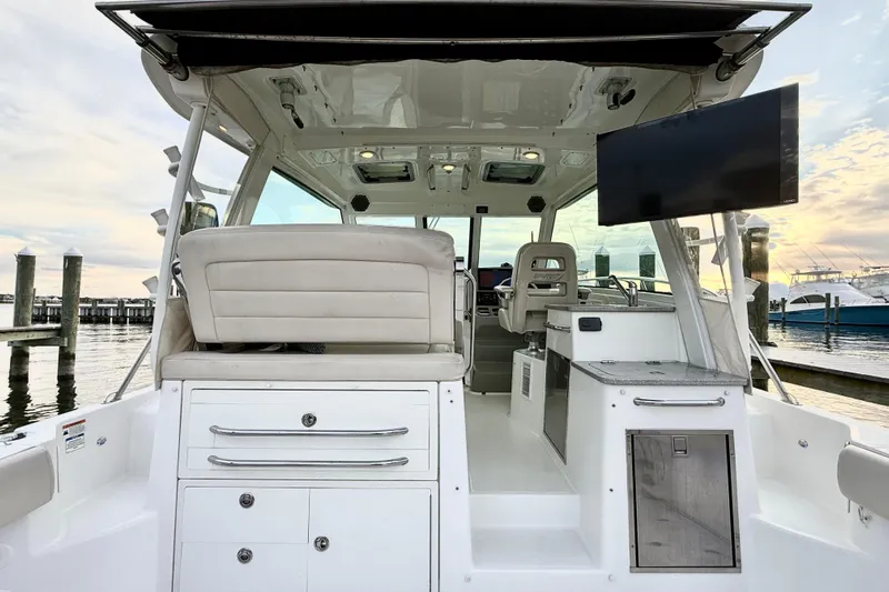  Yacht Photos Pics 2014 Boston Whaler 345 Conquest Pilothouse interior with seating and dockside view.