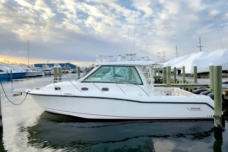  Yacht Photos Pics 2014 Boston Whaler 345 Conquest Pilothouse docked at marina under cloudy sky.