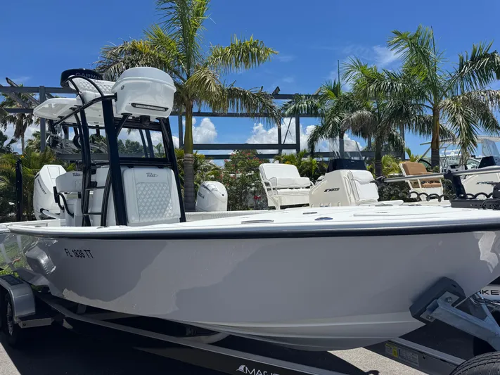  Yacht Photos Pics 2024 Tides 26 boat on trailer, surrounded by palm trees under a clear blue sky.