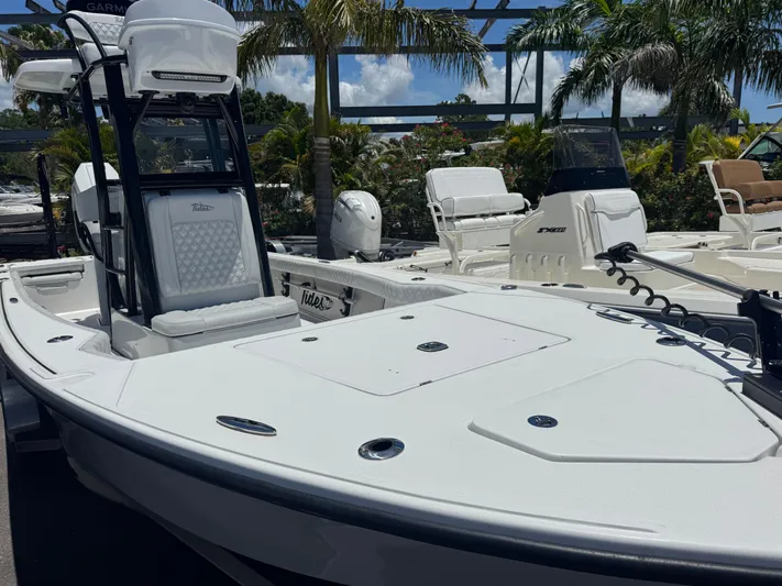  Yacht Photos Pics 2024 Tides 26 boat with sleek design, white exterior, and modern seating, surrounded by palm trees.