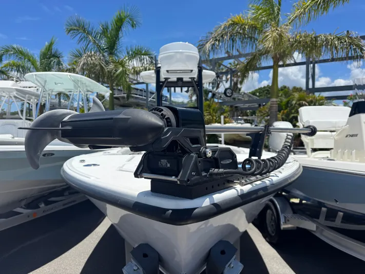  Yacht Photos Pics 2024 Tides 26 boat with trolling motor, surrounded by palm trees and other boats.