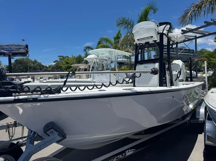  Yacht Photos Pics 2024 Tides 26 boat on trailer, surrounded by palm trees under a clear blue sky.