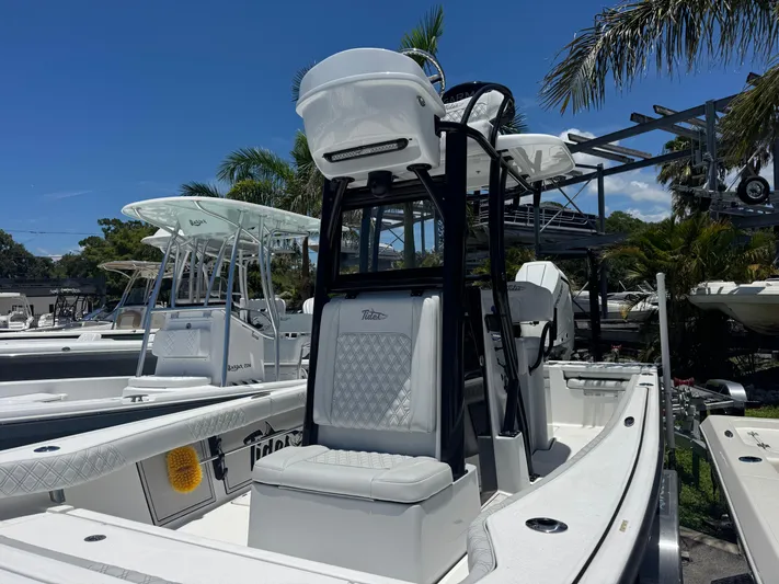  Yacht Photos Pics 2024 Tides 26 boat with sleek design, white seating, and palm trees in the background.