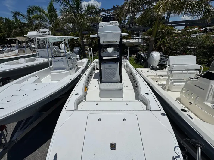  Yacht Photos Pics 2024 Tides 26 boat with sleek design, surrounded by palm trees and other boats.