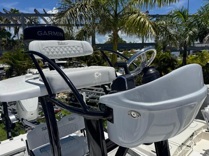  Yacht Photos Pics 2024 Tides 26 boat helm with Garmin equipment, surrounded by tropical palm trees.
