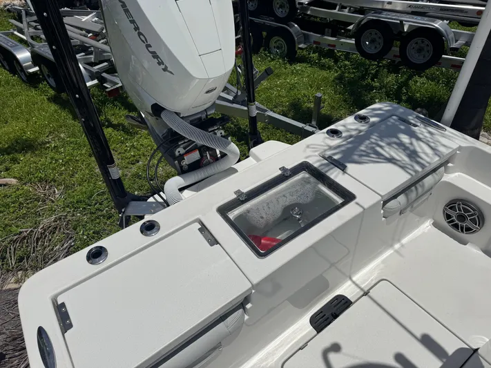  Yacht Photos Pics 2024 Tides 26 boat deck with Mercury engine, featuring storage compartments and speaker.