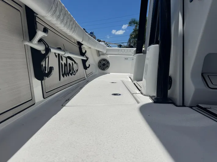 Yacht Photos Pics 2024 Tides 26 boat interior with rod holders and logo under clear blue sky.