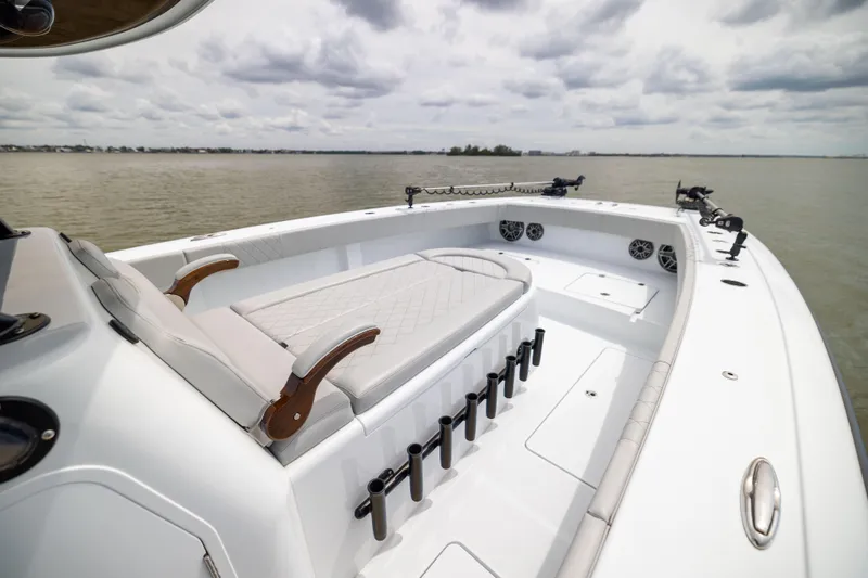  Yacht Photos Pics 2025 Freeman 42 LR boat interior with cushioned seating and rod holders on a calm lake.