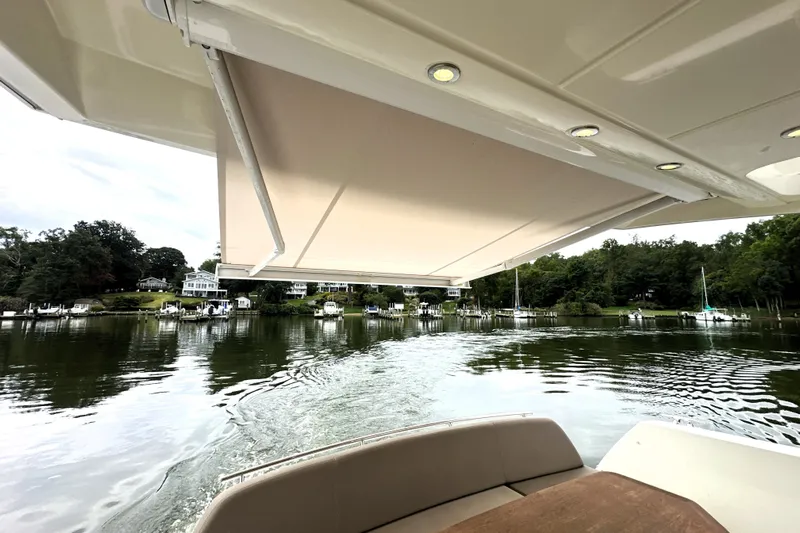 Snusie Q Yacht Photos Pics Prestige 450 yacht, 2014 model, cruising on a serene lake with scenic shoreline views.