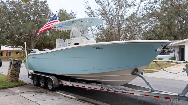  Yacht Photos Pics 2023 Cobia 280 Center Console boat on trailer with American flag.
