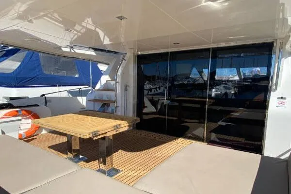  Yacht Photos Pics Outdoor seating area on a 2014 Galeon 550 Fly yacht with wooden table and cushioned seats.