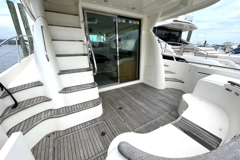 Our Three Buoys Yacht Photos Pics 2007 Prestige 46 Flybridge yacht deck with stairs and sliding glass door.