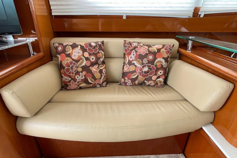 Our Three Buoys Yacht Photos Pics Beige leather sofa with floral cushions in 2007 Prestige 46 Flybridge yacht interior.