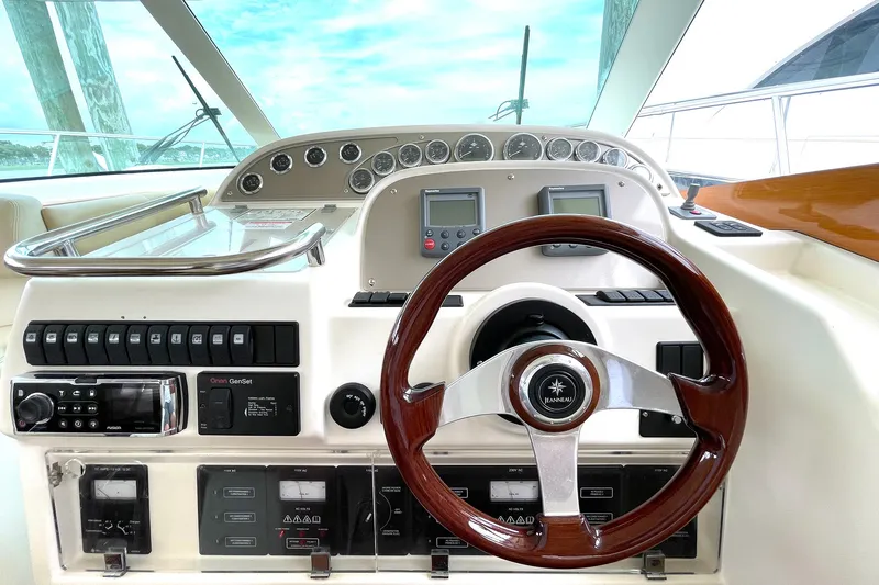 Our Three Buoys Yacht Photos Pics Control panel of a 2007 Prestige 46 Flybridge yacht with wooden steering wheel.
