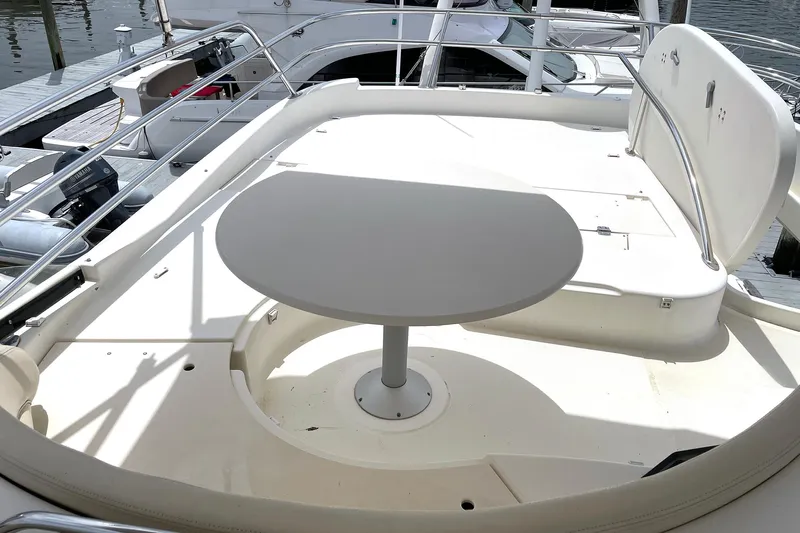 Our Three Buoys Yacht Photos Pics Flybridge seating area on 2007 Prestige 46 yacht with round table and railing.