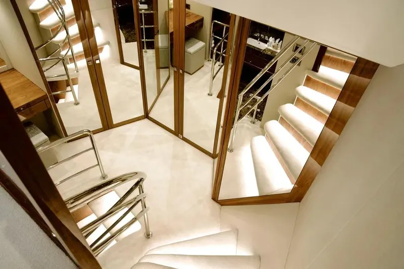  Yacht Photos Pics Luxurious interior staircase of 2018 Sunseeker 95 yacht with elegant wood and metal finishes.