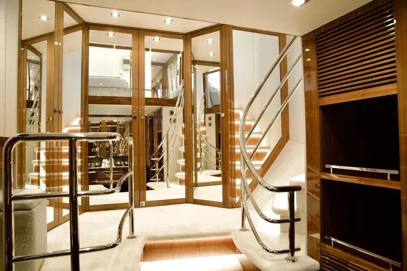  Yacht Photos Pics Luxurious interior of 2018 Sunseeker 95 yacht with elegant staircase and mirrored walls.