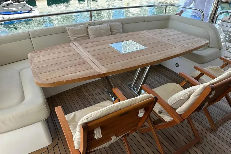  Yacht Photos Pics Luxurious Sunseeker 95 yacht deck with wooden table and cushioned seating, 2018 model.
