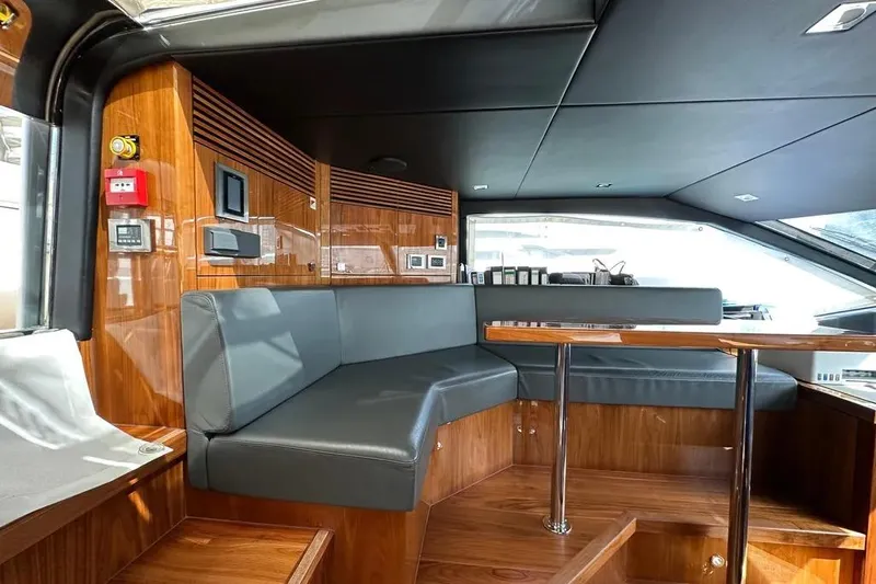  Yacht Photos Pics Luxurious interior of 2018 Sunseeker 95 yacht with sleek wood finishes and modern seating.