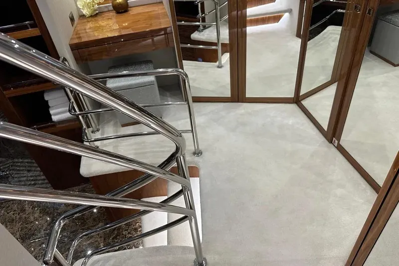  Yacht Photos Pics Luxurious interior of 2018 Sunseeker 95 yacht with elegant staircase and mirrored walls.